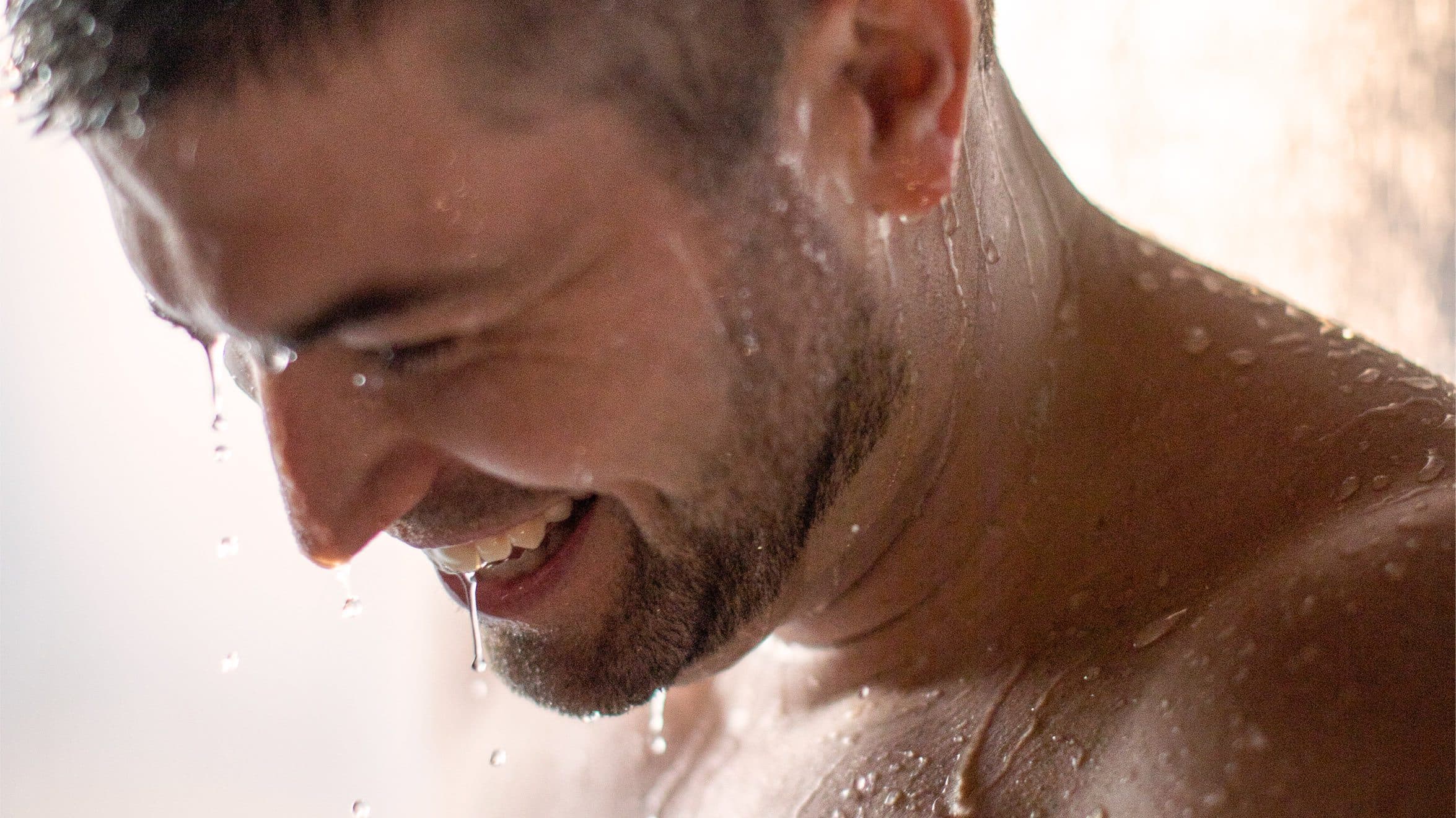 A man at Scandinave Spa enjoying a cold shower and the boost of feel-good hormones.