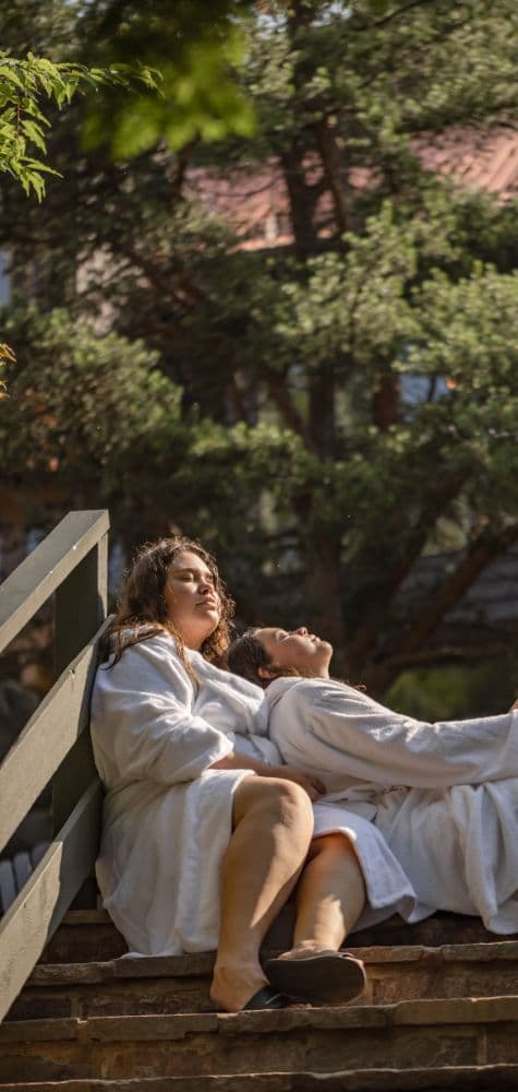 two people in bath robes resting outside