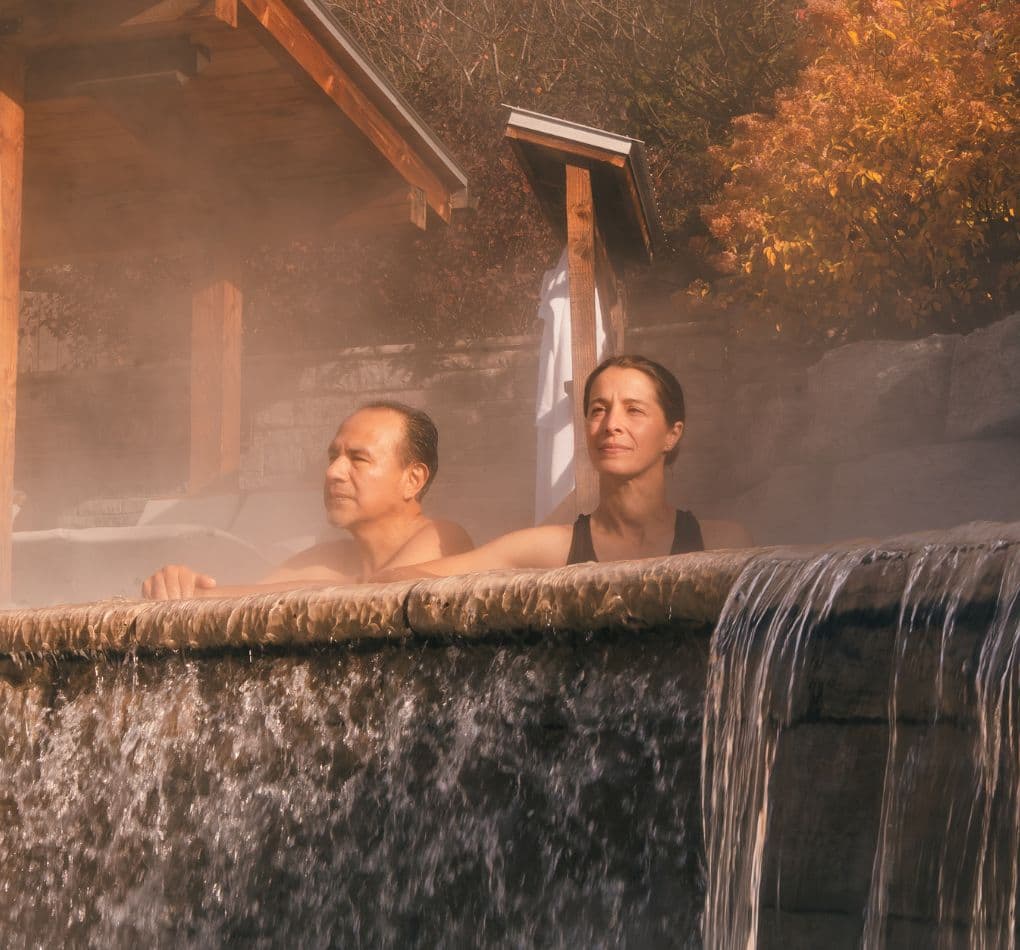 A man and a woman in the Infinity thermal pool, experiencing pure relaxation.
