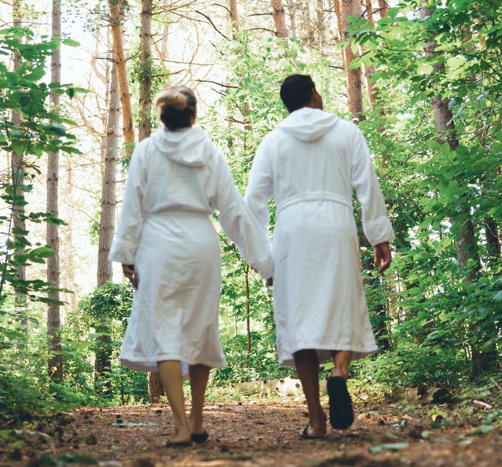 A couple walking the Forest Bathing trail at Scandinave Spa Blue Mountain.